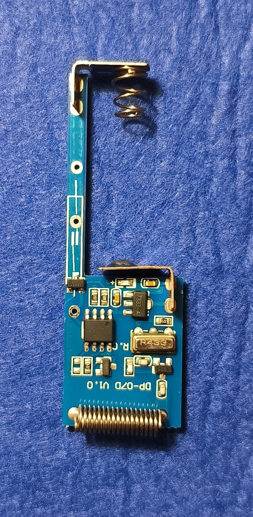 The sensor's PCB, bent into an L shape to fit the case, with the RF section, antenna spring and microcontroller visible